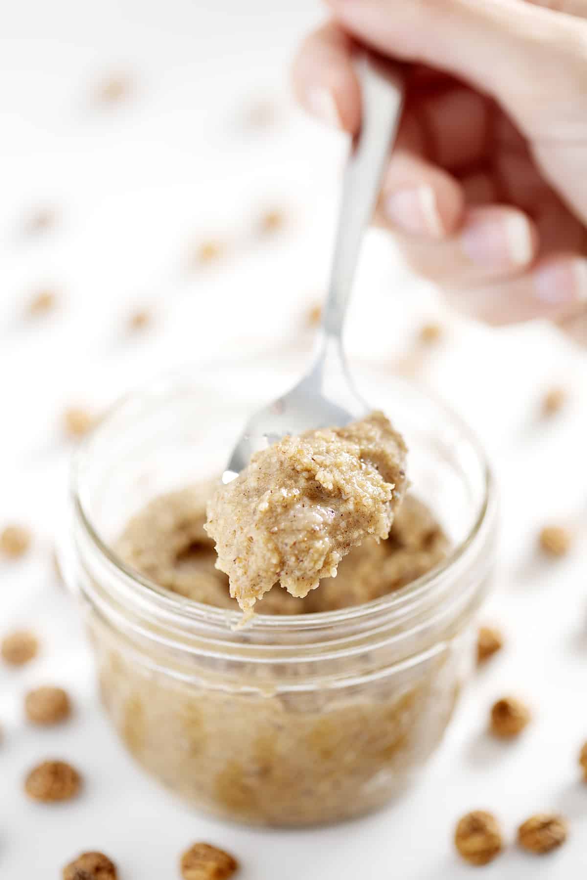 spoonful of Tigernut Butter with mason jar and whole tigernuts