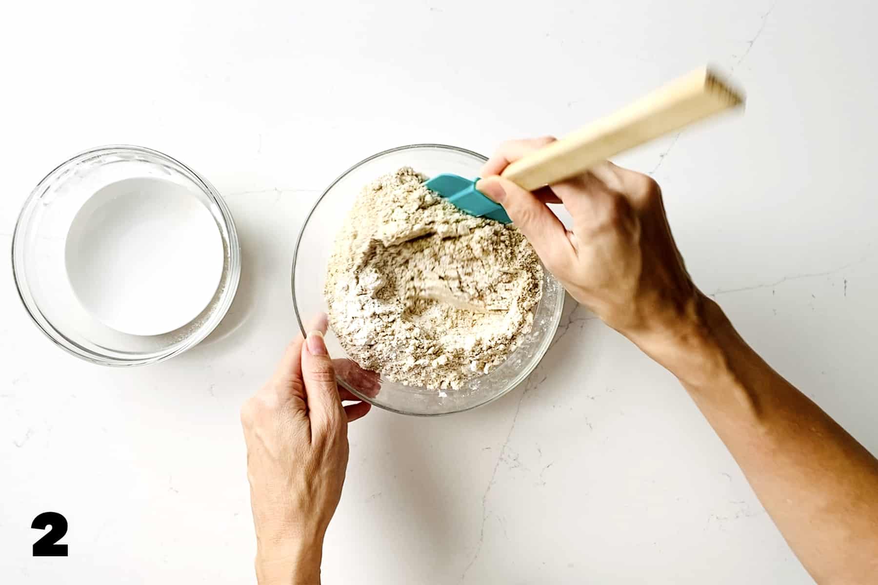 mixing bowl of flour with teal spatula