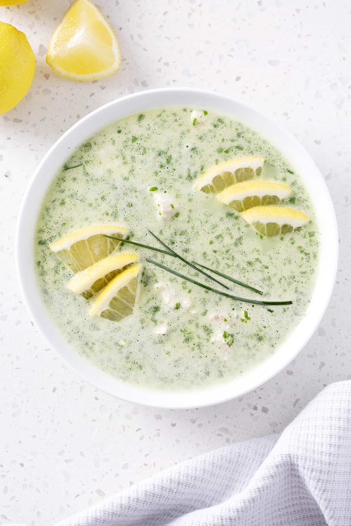 bowl of soup garnished with lemon and chives