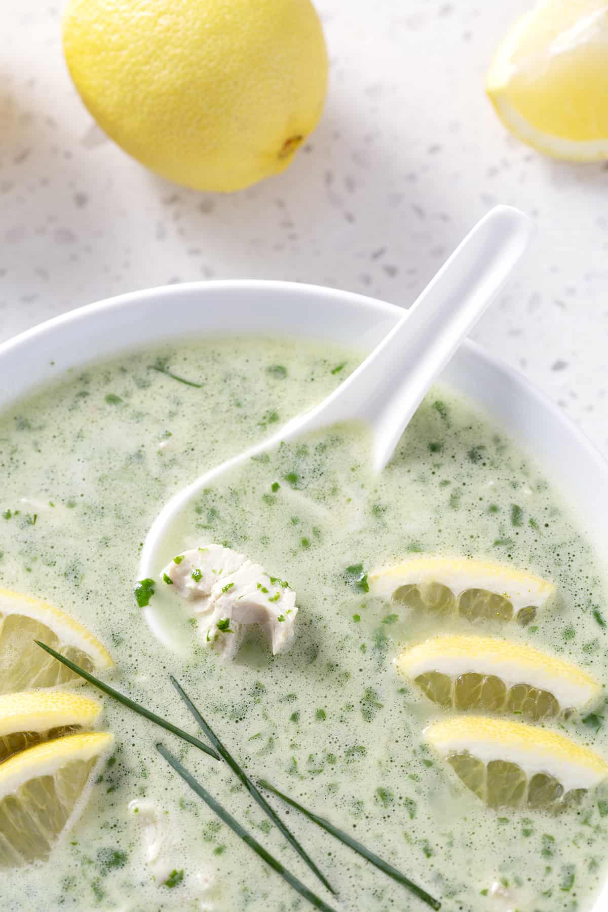 bowl of soup with soup and garnished with lemon and chives