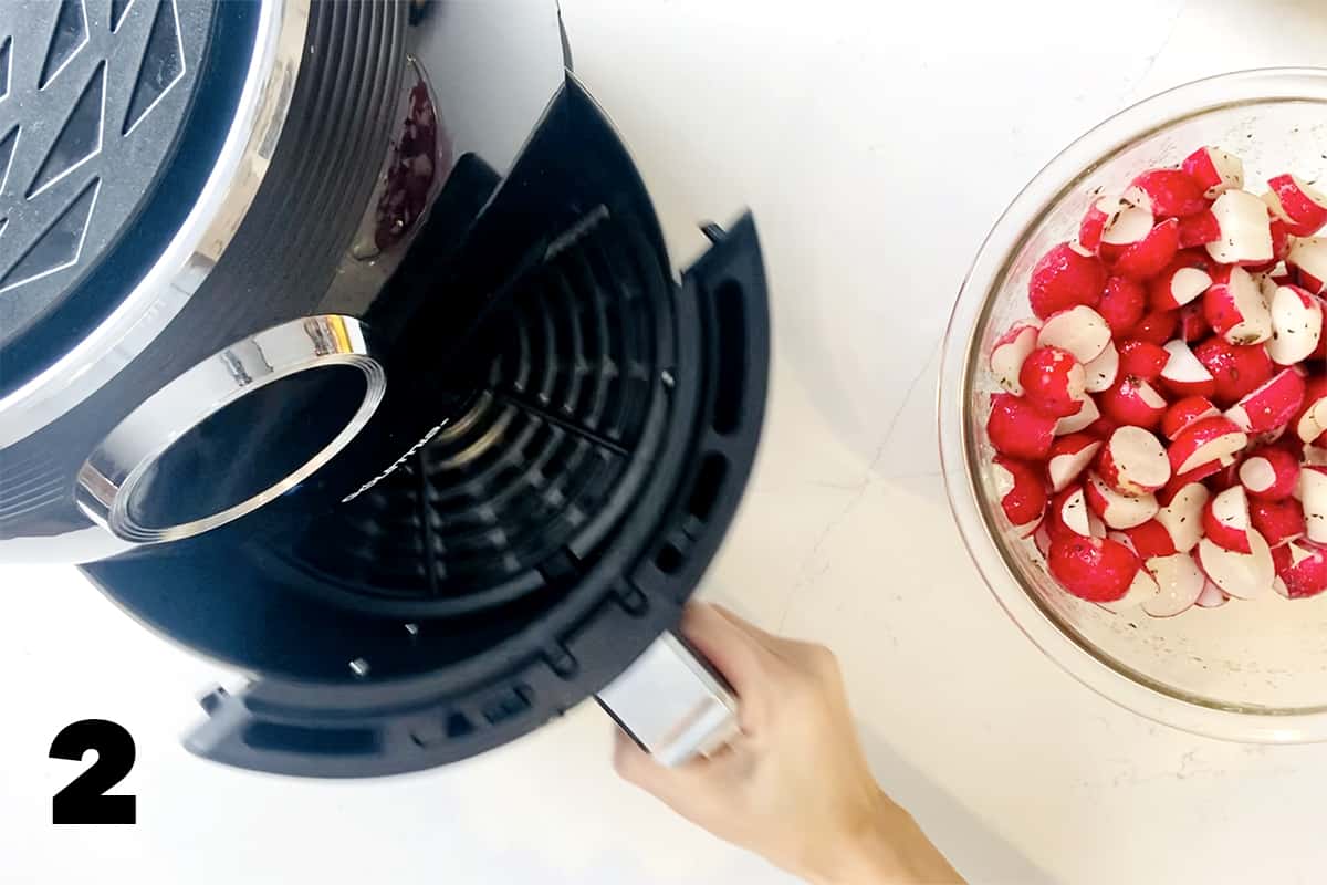removing air fryer basket with bowl of radishes