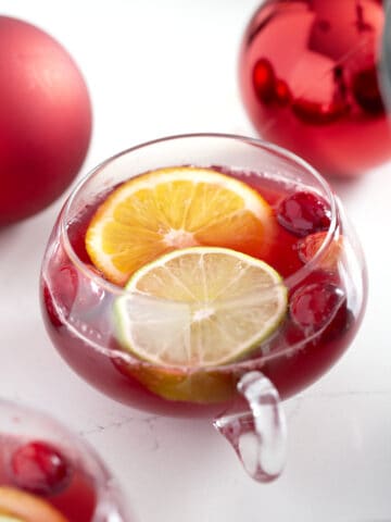 punch glass with non alcoholic Christmas punch, citrus slices and cranberries