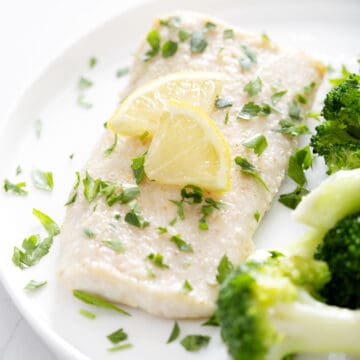halibut fillet with parsley and lemon slices on plate