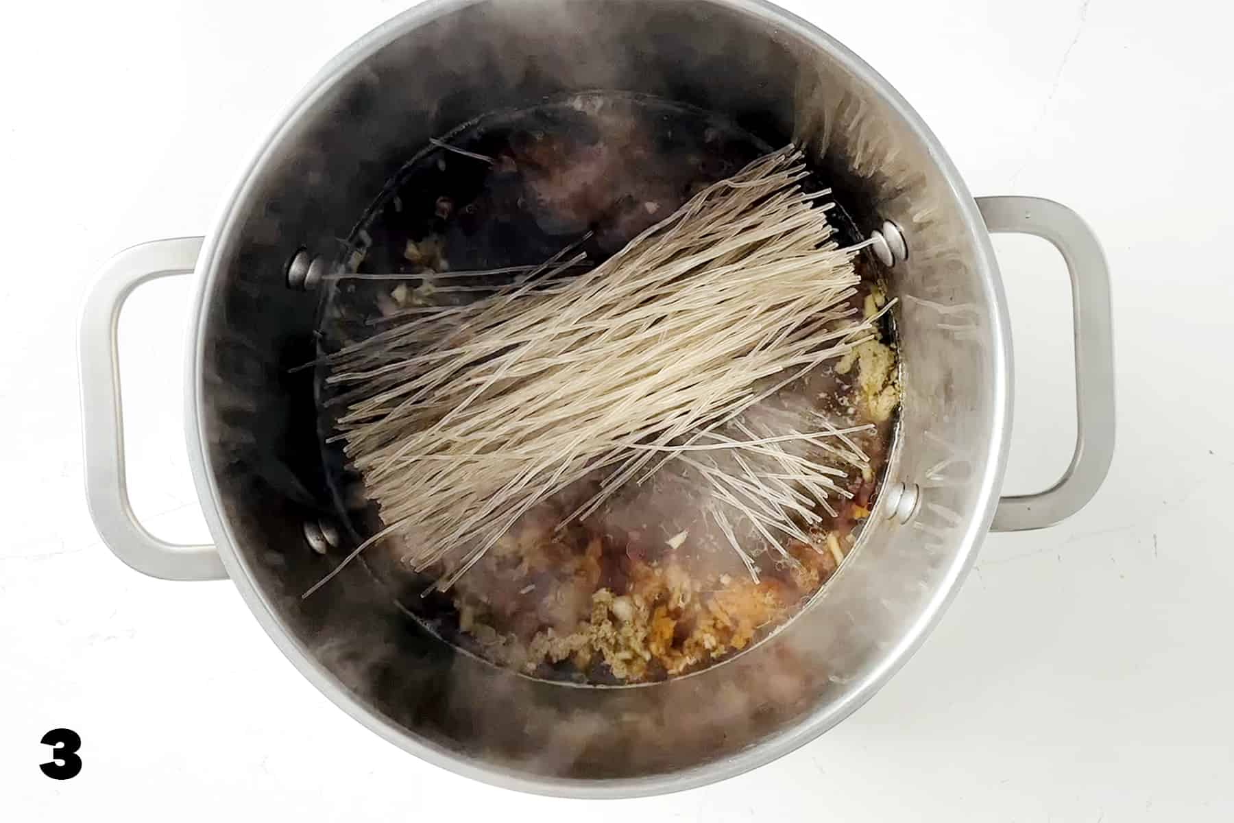 glass noodles in stockpot with soup