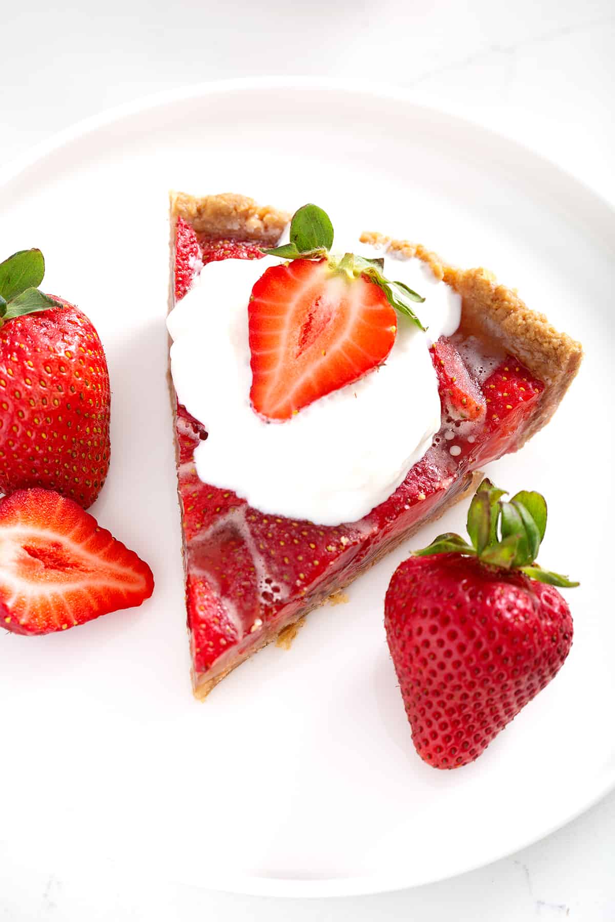 strawberry pie with graham cracker crust topped with whipped cream