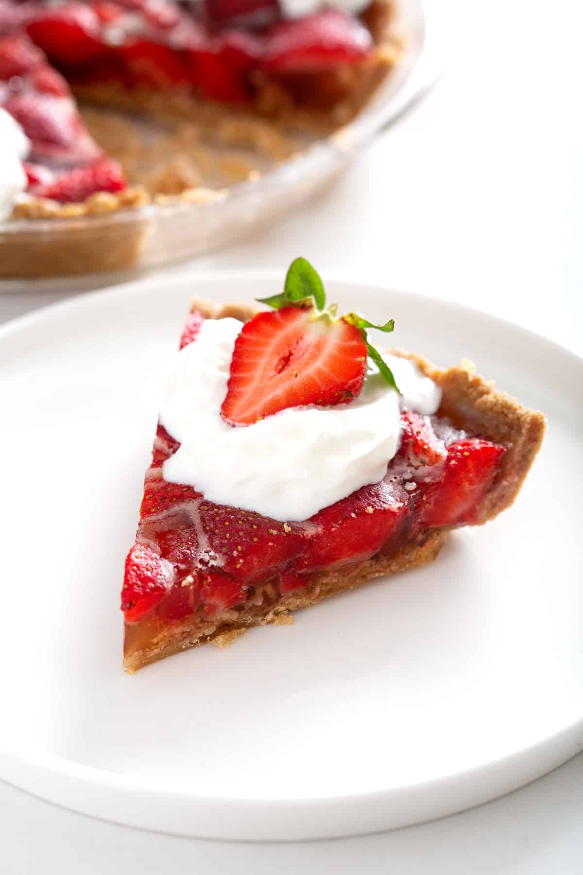 piece of strawberry pie with graham cracker crust on plate
