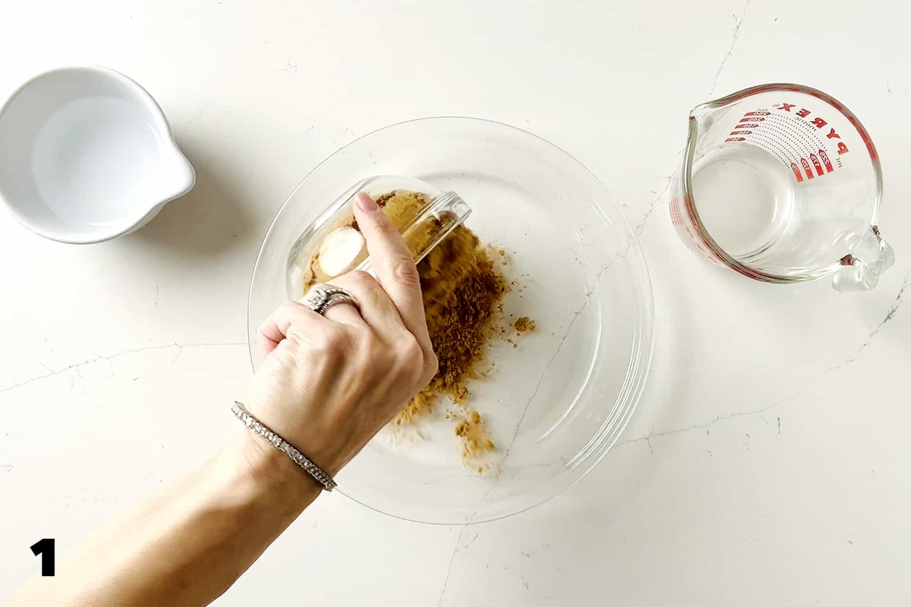 pouring graham cracker crumbs into pie plate