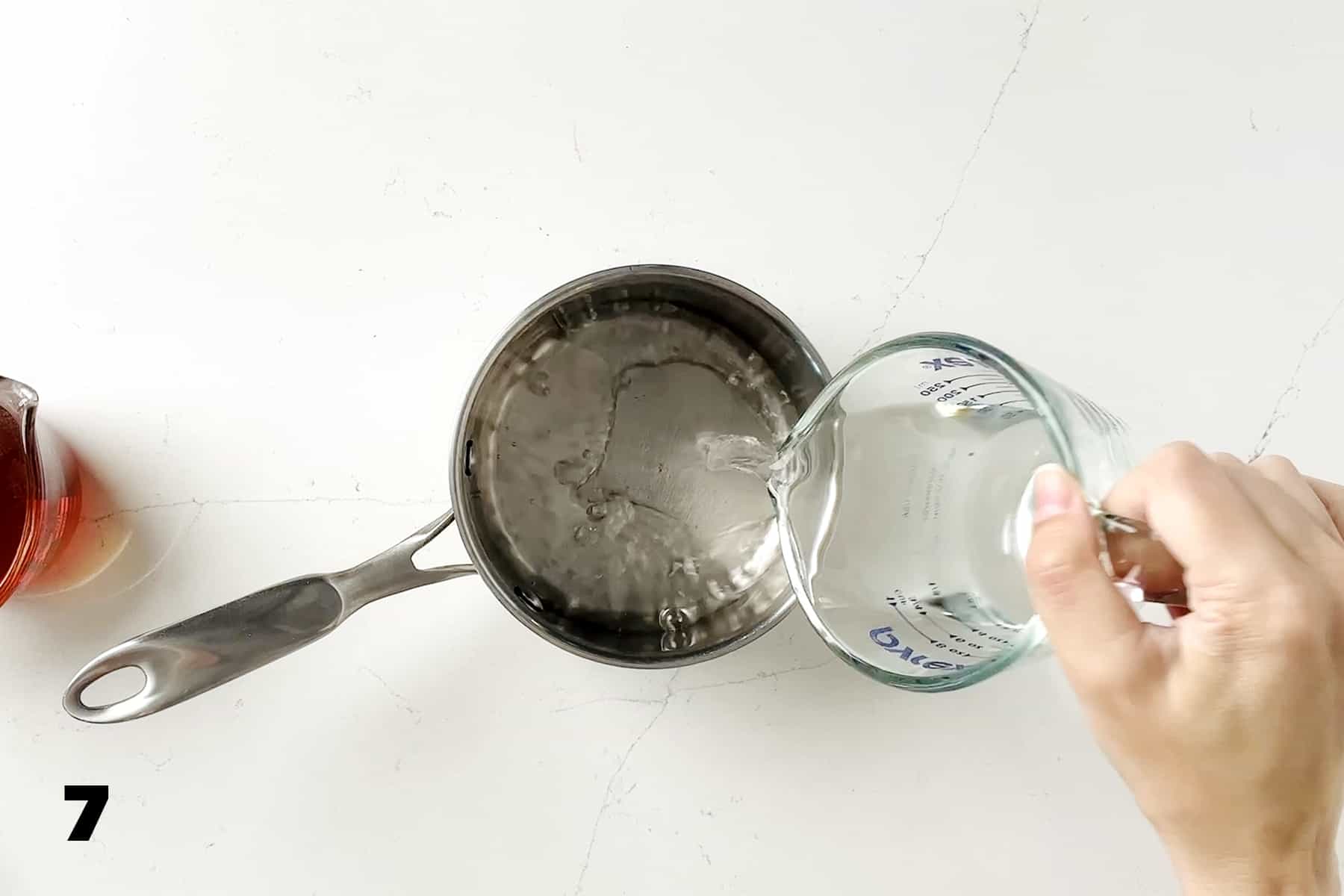 pouring water into small saucepan