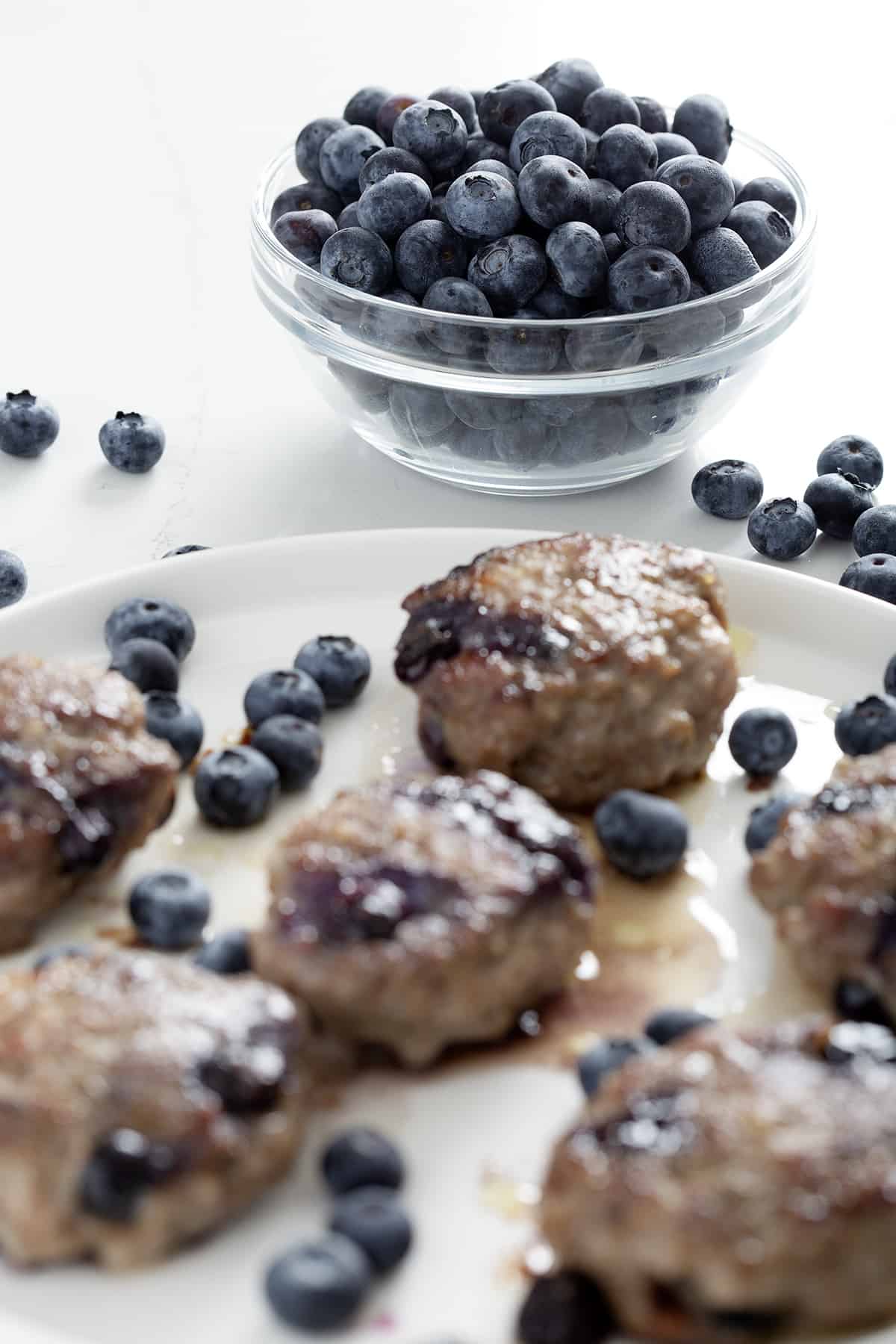 bowl of blueberries with blueberry sausage in foreground