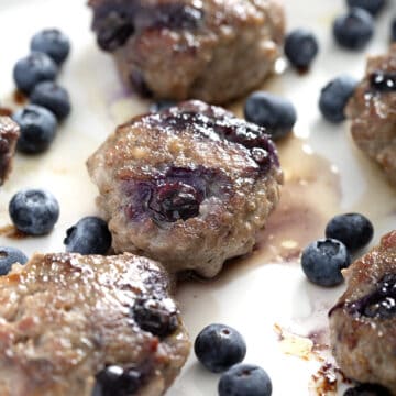 plate of blueberry sausages with fresh blueberries