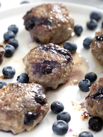 plate of blueberry sausages with fresh blueberries
