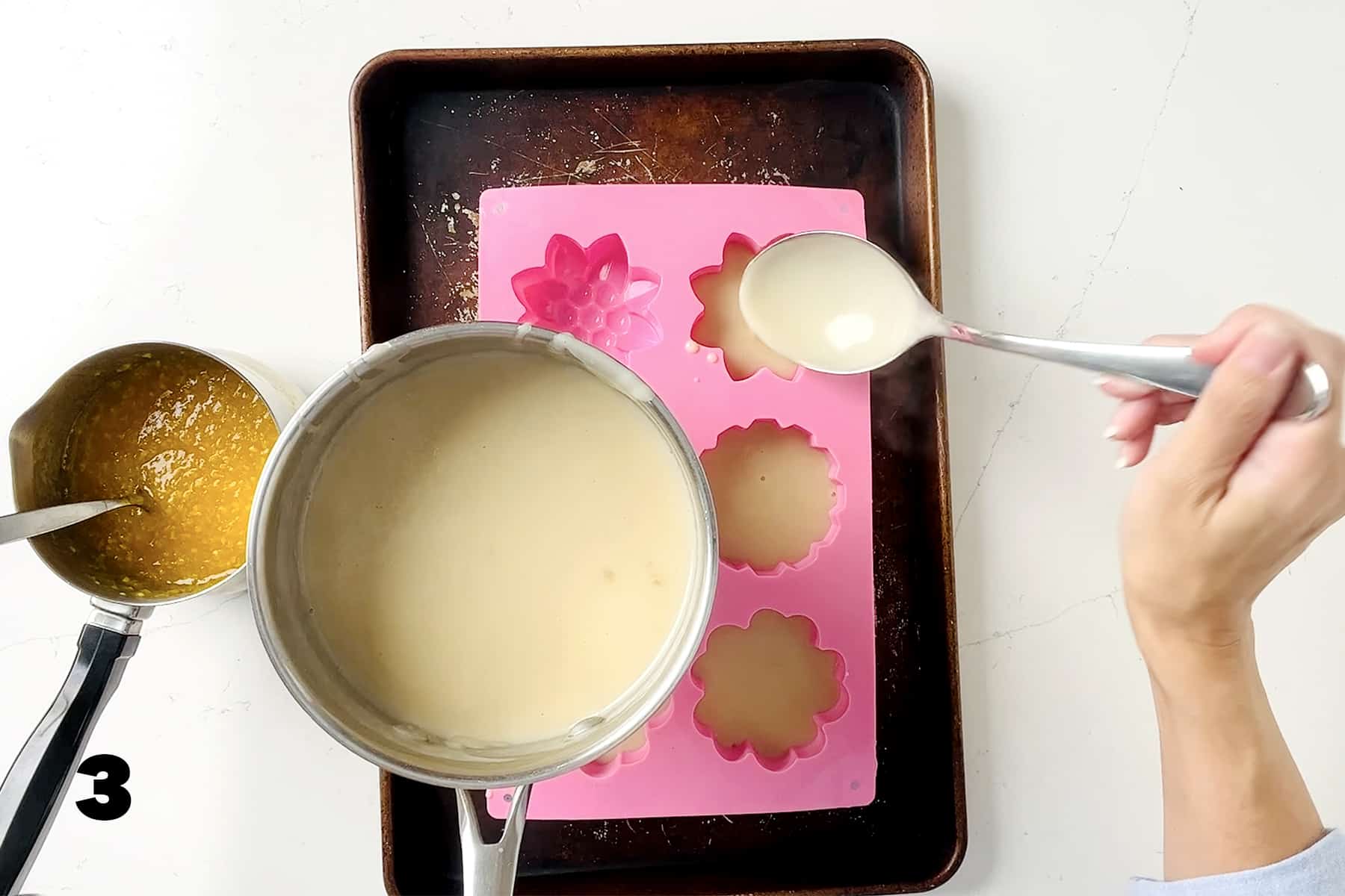spooning coconut mixture into pink mold