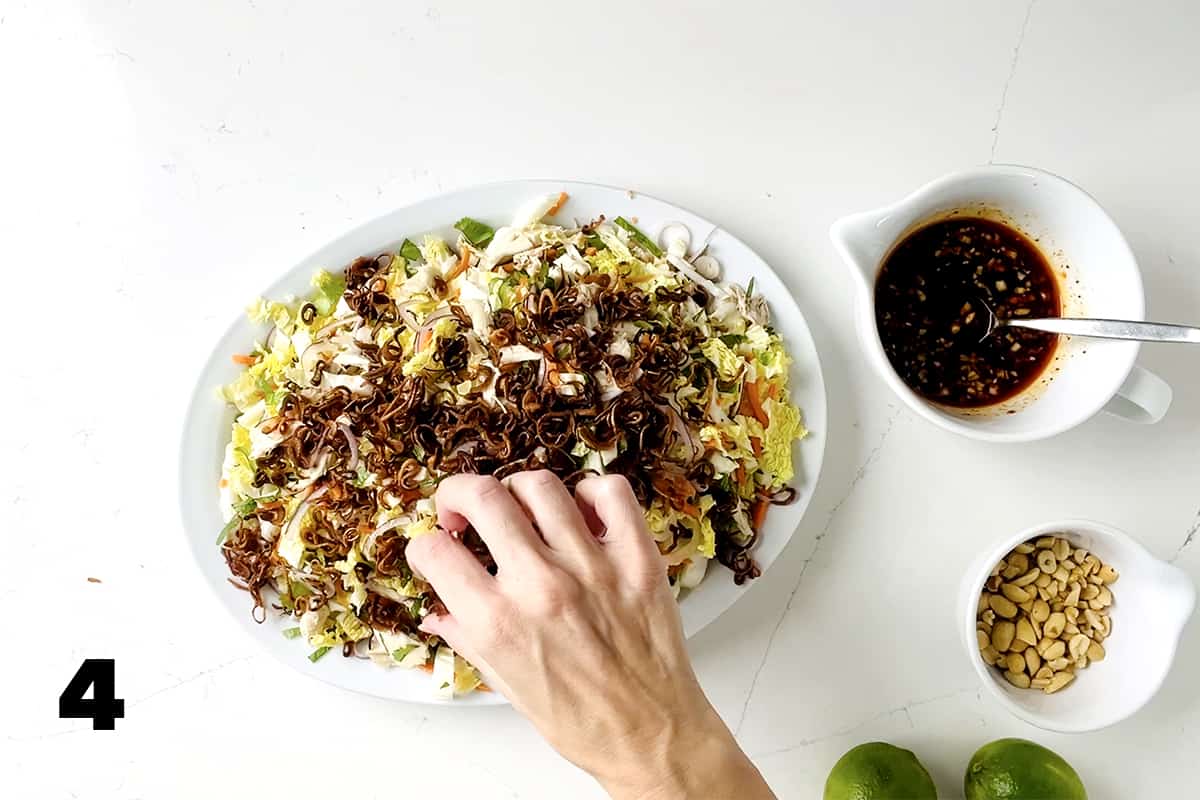 platter of salad with hands adding toppings