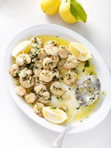 plate of dairy free shrimp scampi on platter with lemon