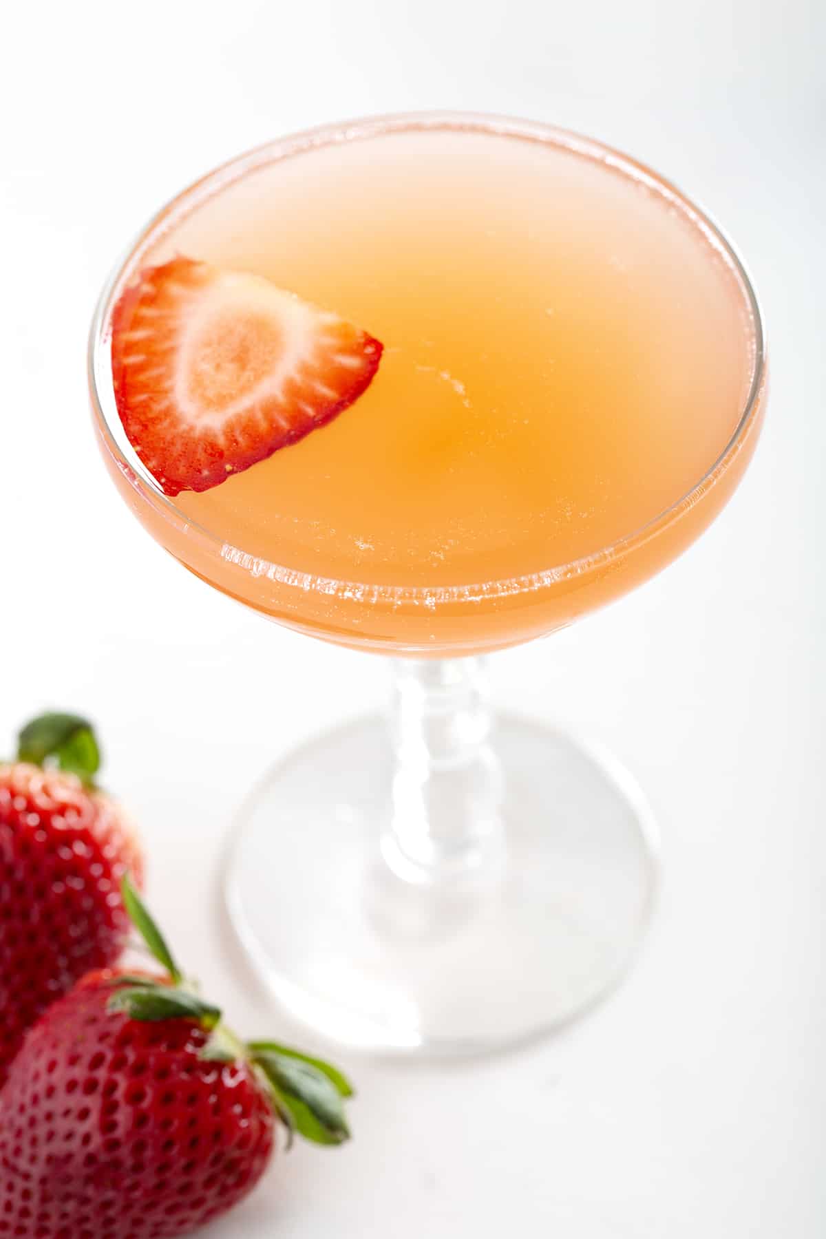 champagne coupe of Strawberry Rhubarb French 75 with strawberries