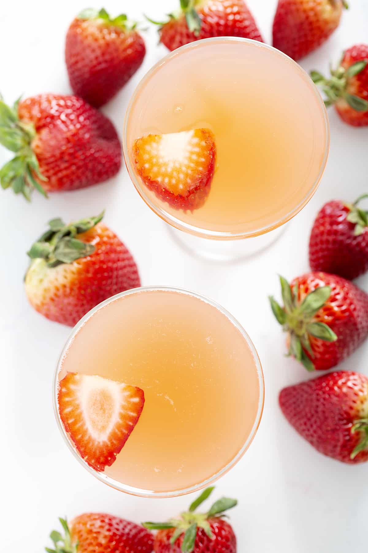 champagne coupe glasses filled with strawberry rhubarb french 75 from above