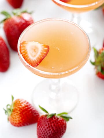 champagne coupe of strawberry rhubarb french 75 with strawberries