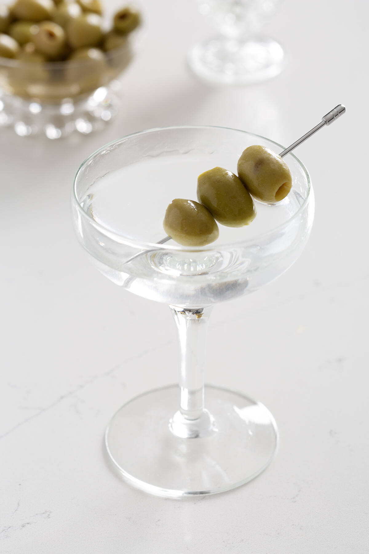 dry gin martini with olives on white counter