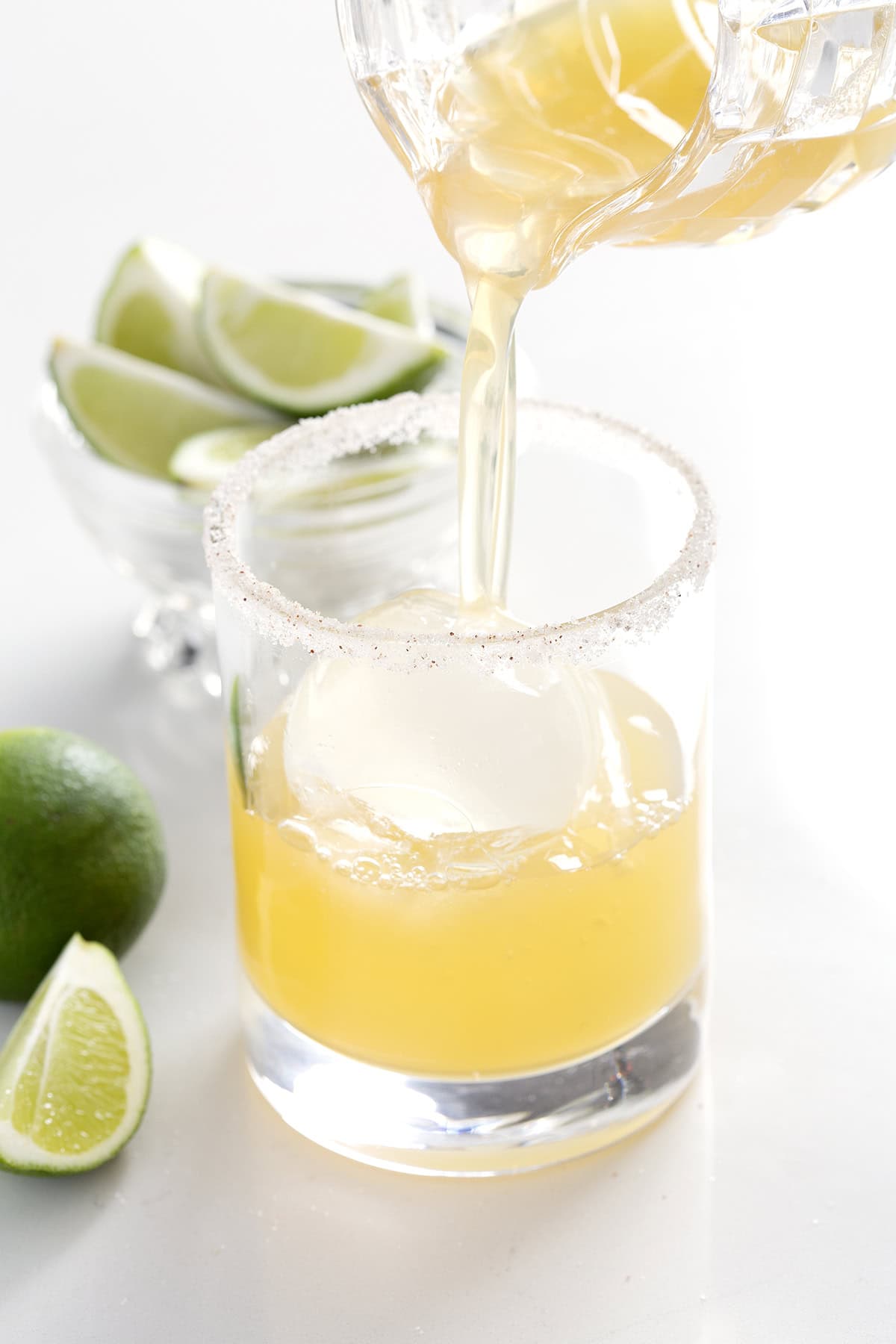 pouring margarita over ice into glass.