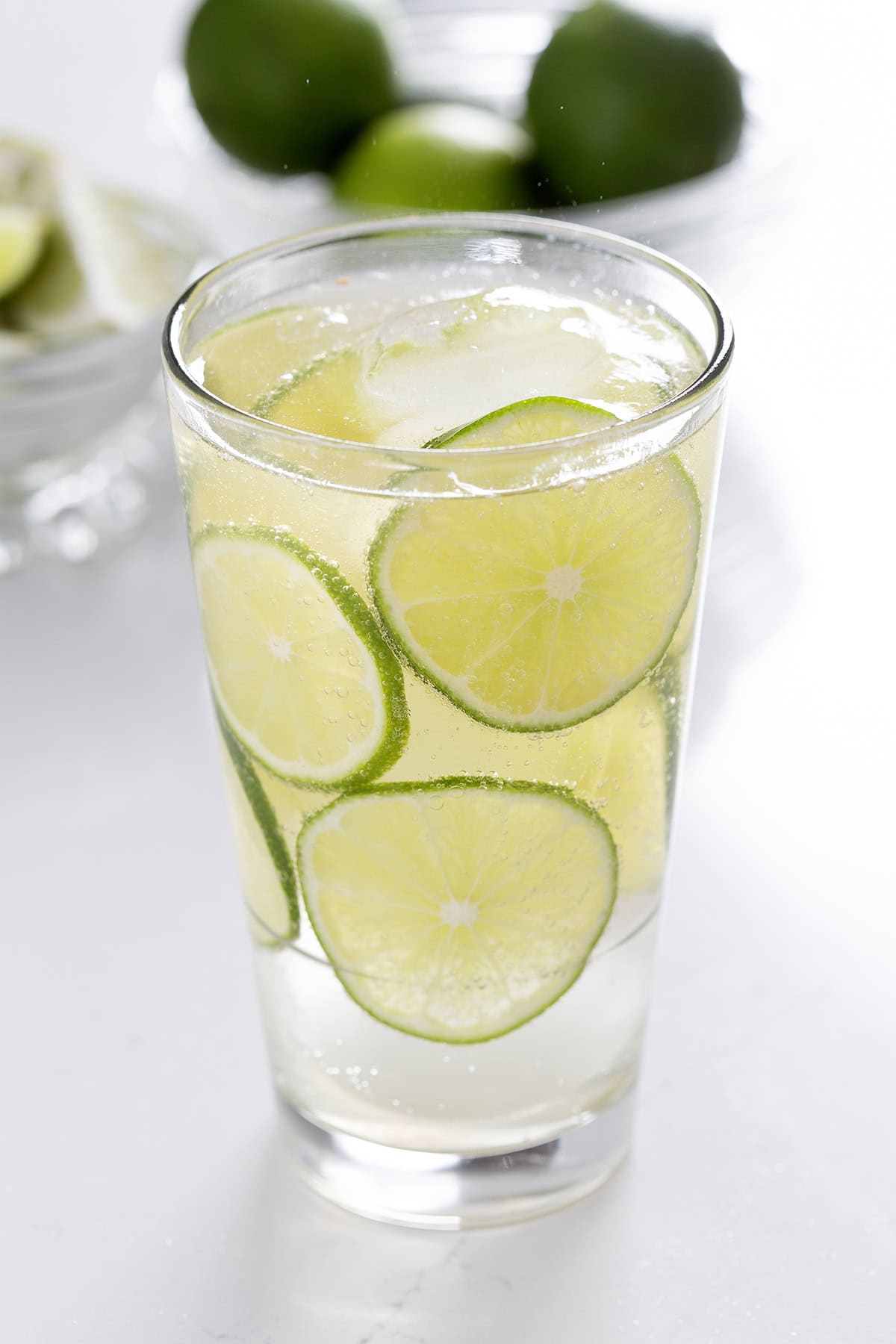 highball glass fill with tequila and soda with lime wheels garnish