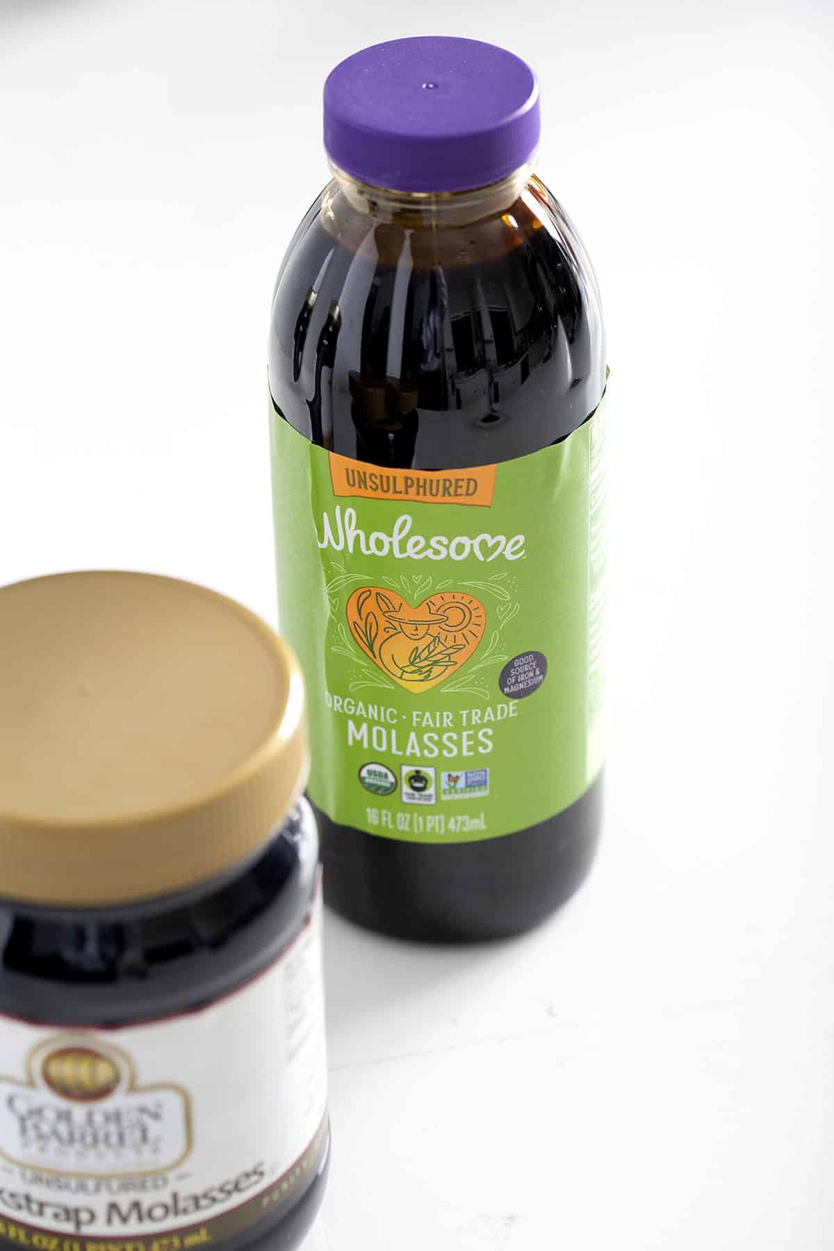 jar of wholesome molasses on white background