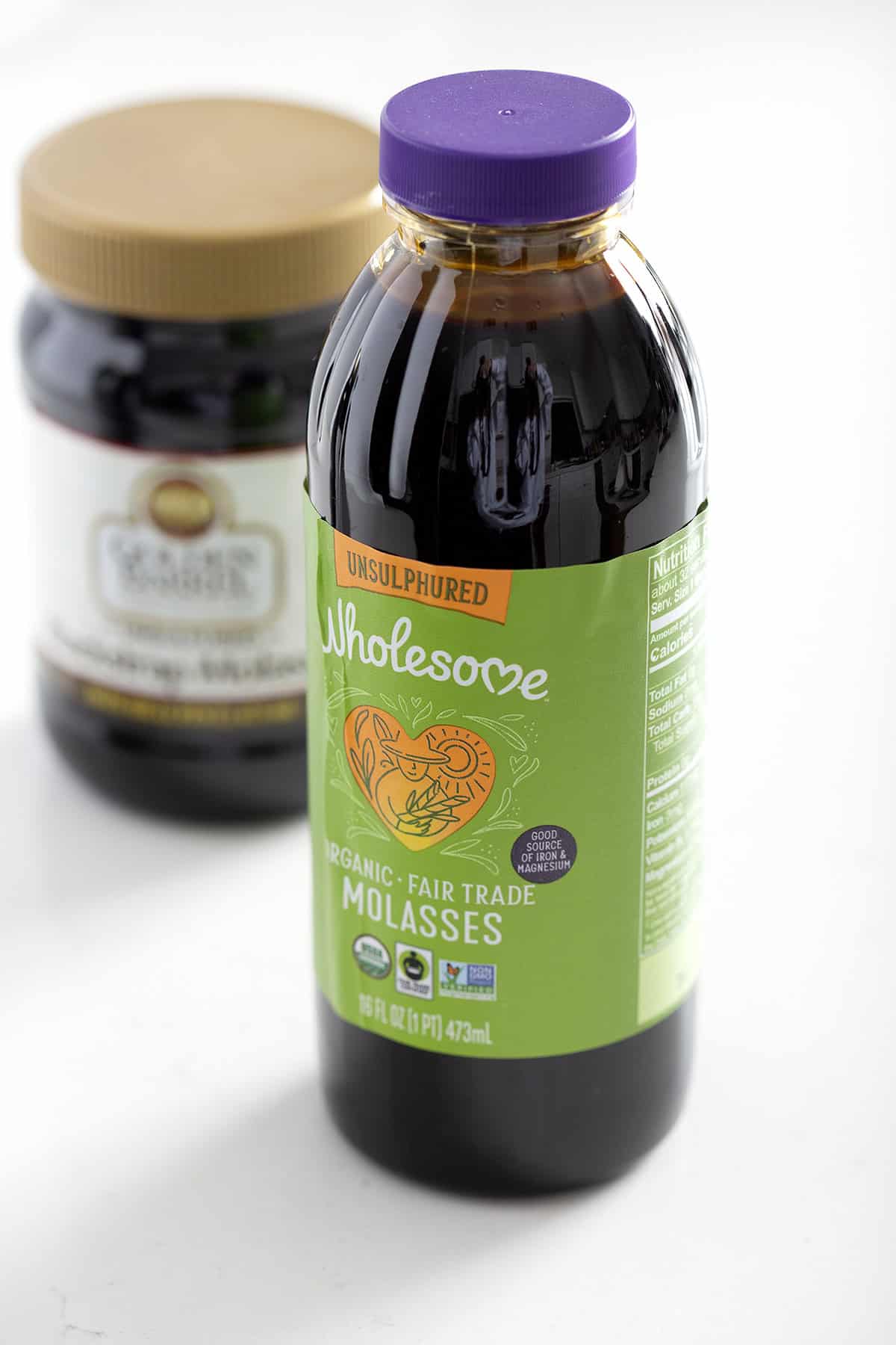 jar of wholesome molasses on white background